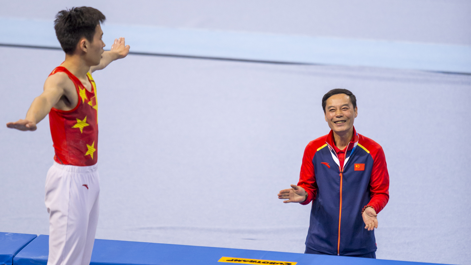 Photographie couleur du chinois Gao Lei, champion du monde de Trampoline, se faisant féliciter par son entraineur