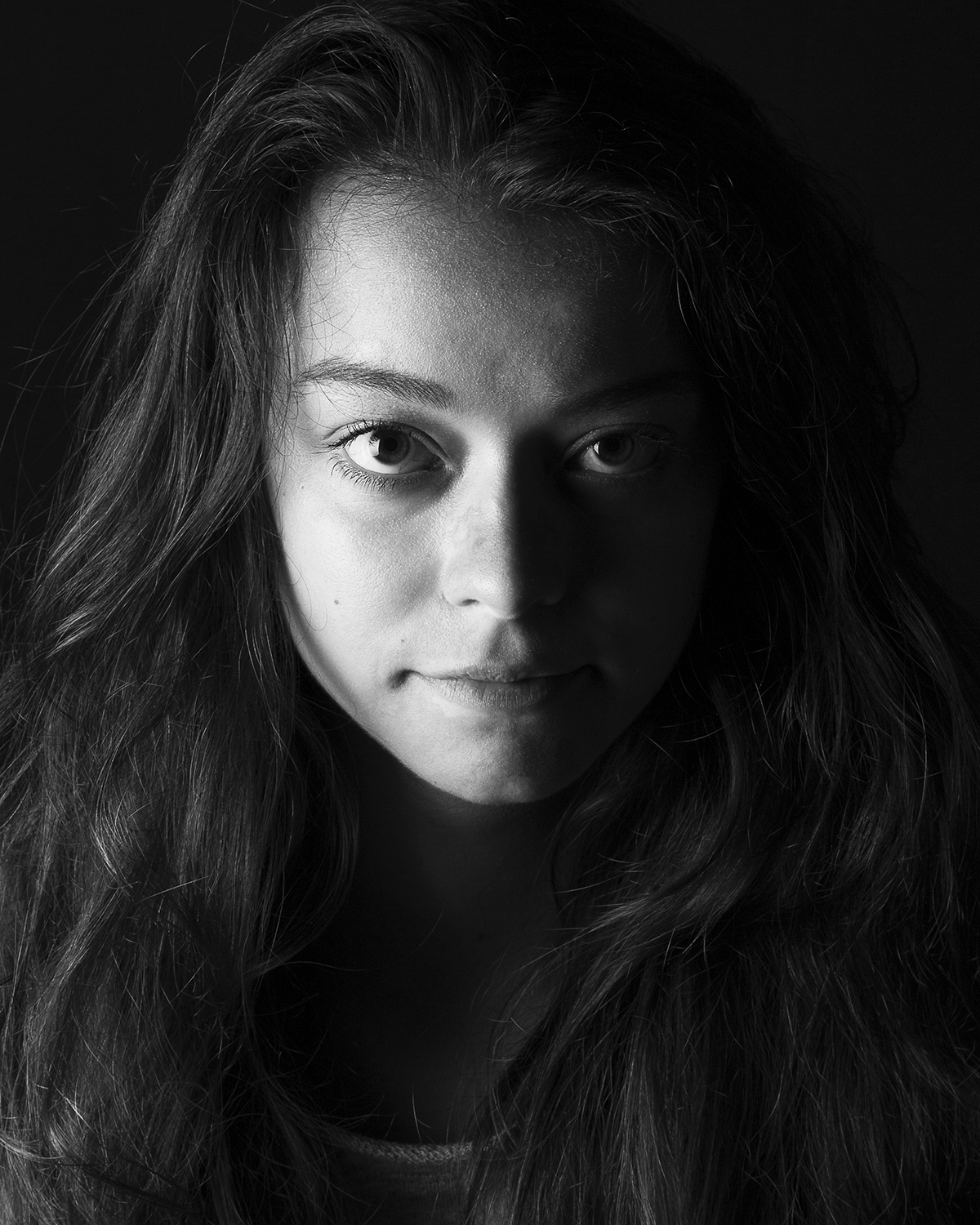 Photographie en niveau de gris de Cléa Schneider éclairée avec un clair-obscur fait en lumière artificielle